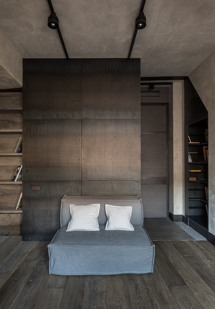 Ruang baca dengan lemari dan kursi bergaya industrial modern