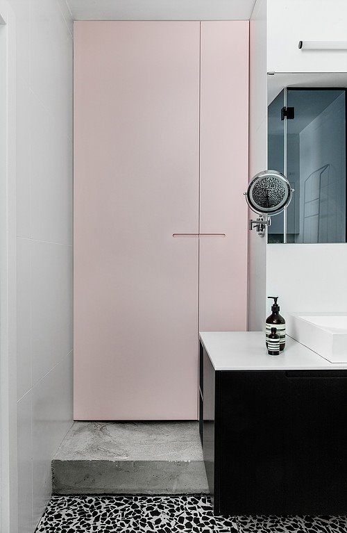 Pastel pink cupboards are placed on cement steps