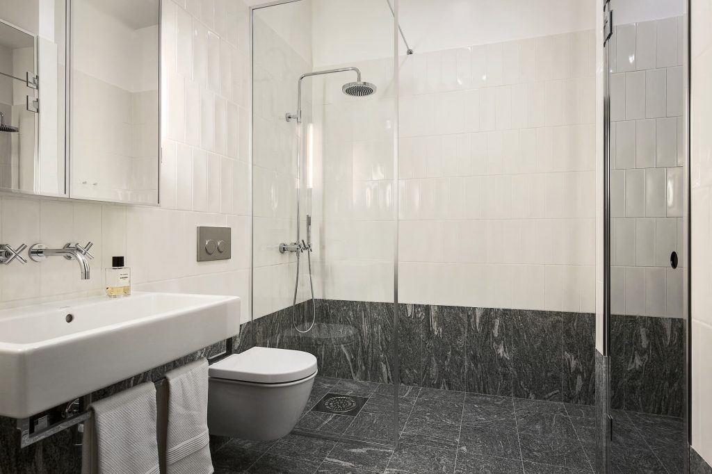 nhà vệ sinh có vách ngăn kính vòi tắm đứng, tủ gướng - một phòng ngủ