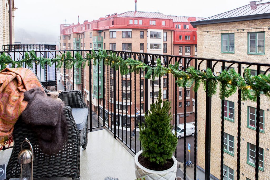 balkon yang lapang dengan penataan bonsai dan kursi malas