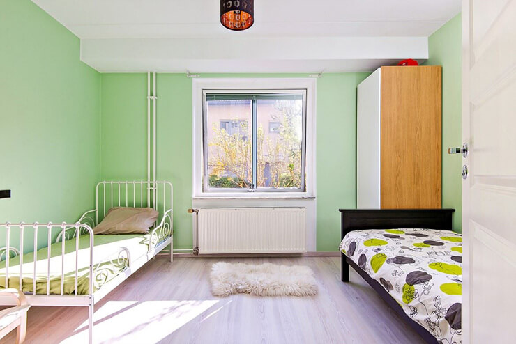 İkinci yatak odası soğuk yeşil tonlara sahiptir.