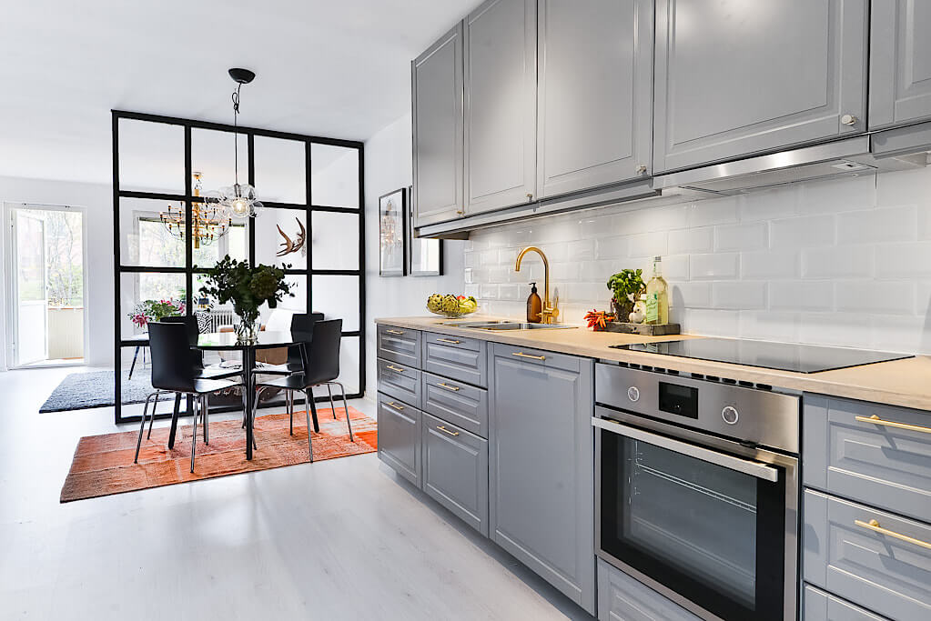 Kệ bếp dùng tông màu xám có bếp từ, lò nướng, máy hút mùi - tự thiết kế nội thất chung cư