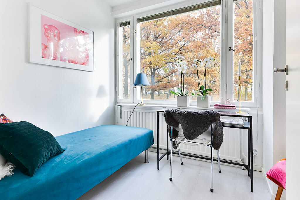 Giường ngủ bộ ga màu xanh và ngay cạnh là bộ bàn ghế làm việc đơn giản - tự thiết kế nội thất chung cư